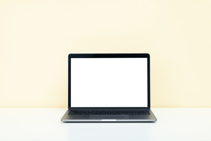 Open laptop with blank mockup screen in cream room