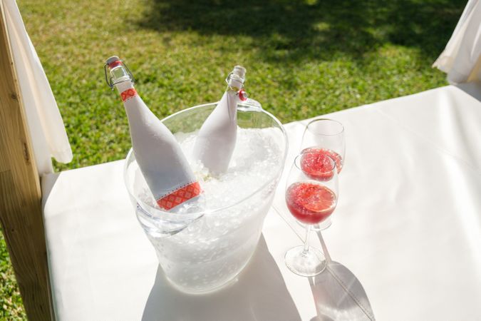 Bottles and glasses with wine on canopy bed