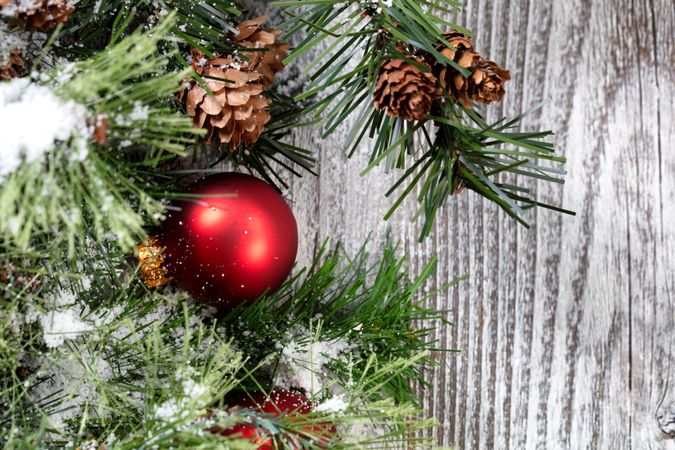 Close up of a red Christmas ball ornament on rustic wood