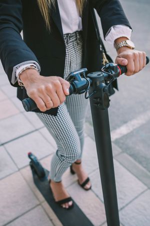 Unrecognizable businesswoman with e-scooter outdoors