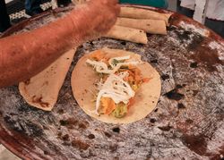 Woman constructing taco on griddle
