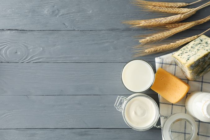 Flat lay. Different dairy products on grey wooden background, copy space