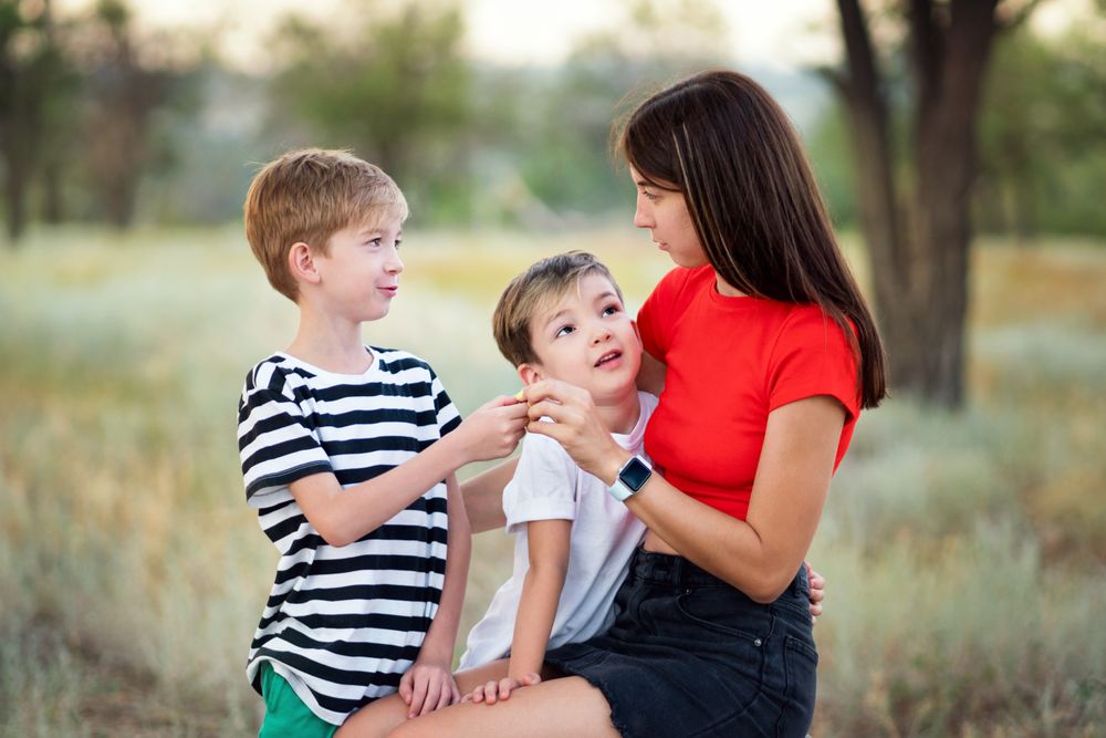 Loving mom with two sons outdoors
