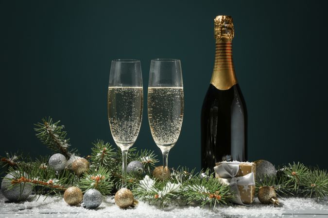 Champagne glasses and bottle on decorated background, space for text