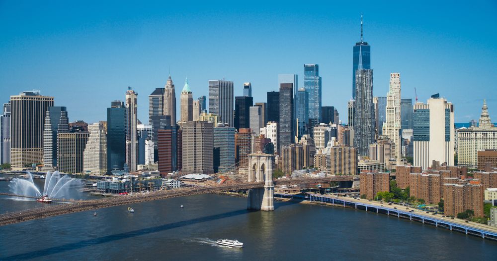 Aerial Cinematic Drone Scene Near Brooklyn Bridge with New York Skyscrapers Cityscape. Beautiful Sun Shining on a Warm Summer Day. Photo of Historic Architecture