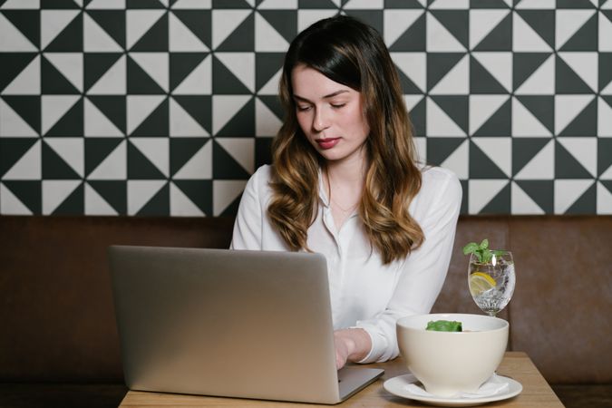 Young woman using laptop in cafe