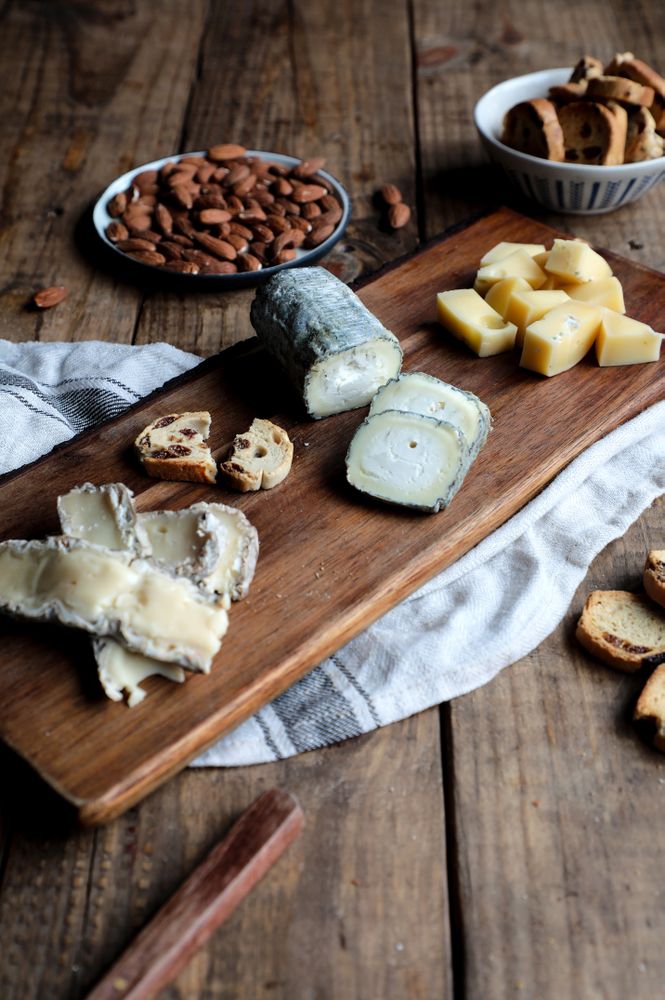 Croutons and nuts near board with cheese