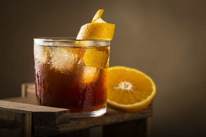 Negroni cocktail with orange, on wooden background.