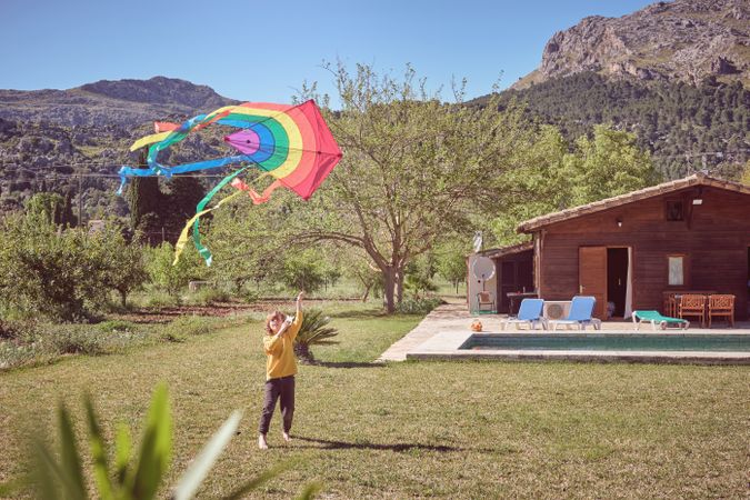 Preschooler playing with kite during strong wind