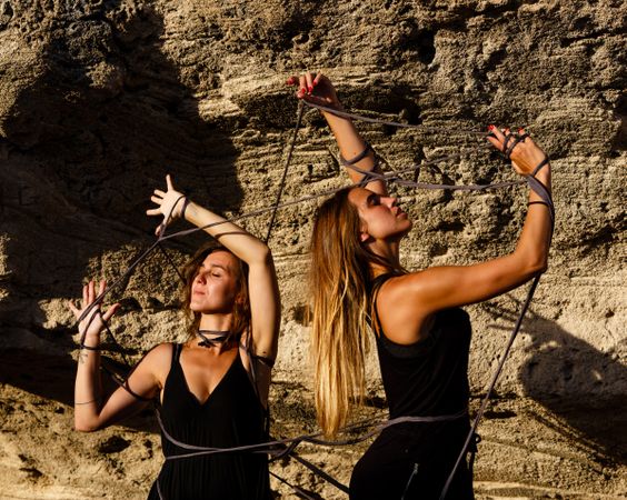 Women with thread posing near stones