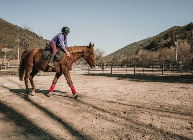 Young woman riding horse on ranch