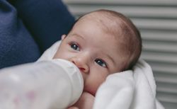 Baby taking feeding bottle