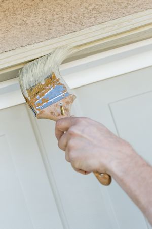 Professional Painter Cutting In With Brush to Paint Garage Door Frame