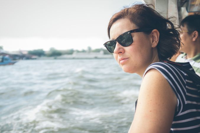 Woman looking at waving sea from ship