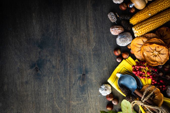 Thanksgiving flatlay with nuts, berries, vegetable and fruits on dark wooden background with copy space