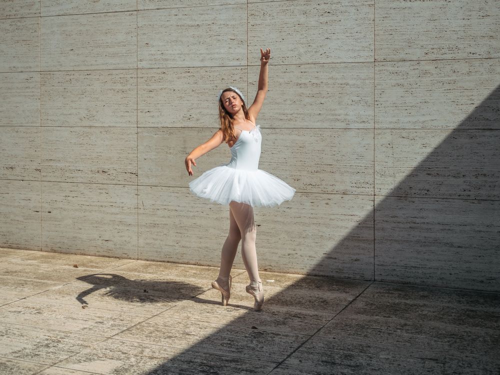 Ballerina doing ballet posing in classroom