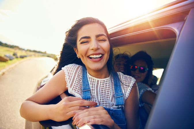 Smiling woman leaning out of car window