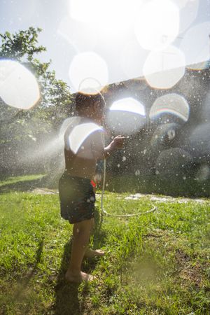 Little kids in swimwear having fun with splashing water