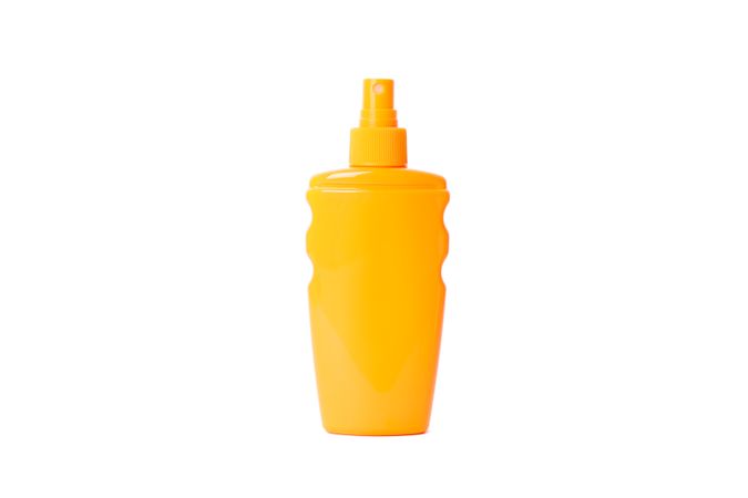 Sunscreen spray isolated on studio background. Summer vacation accessories