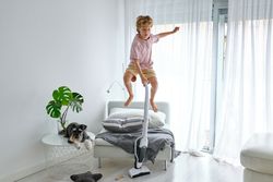Boy jumping and cleaning floor