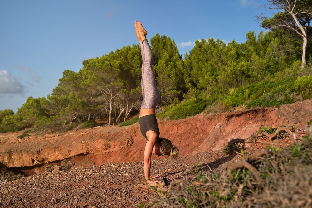 Woman in tights practicing handstand yoga