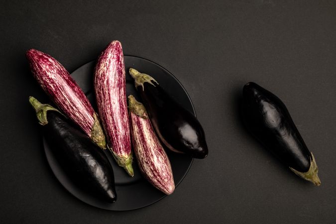 Ripe eggplants on dark tabletop