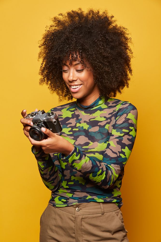 Trendy female paparazzi holding camera