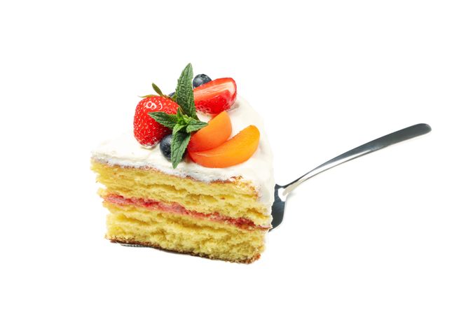 Shovel with berry cream cake isolated on plain background