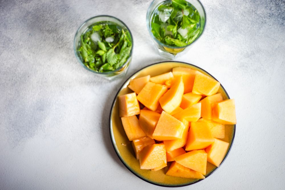 Bowl of melon served with minty drink