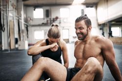 Man and woman laughing together on gym floor