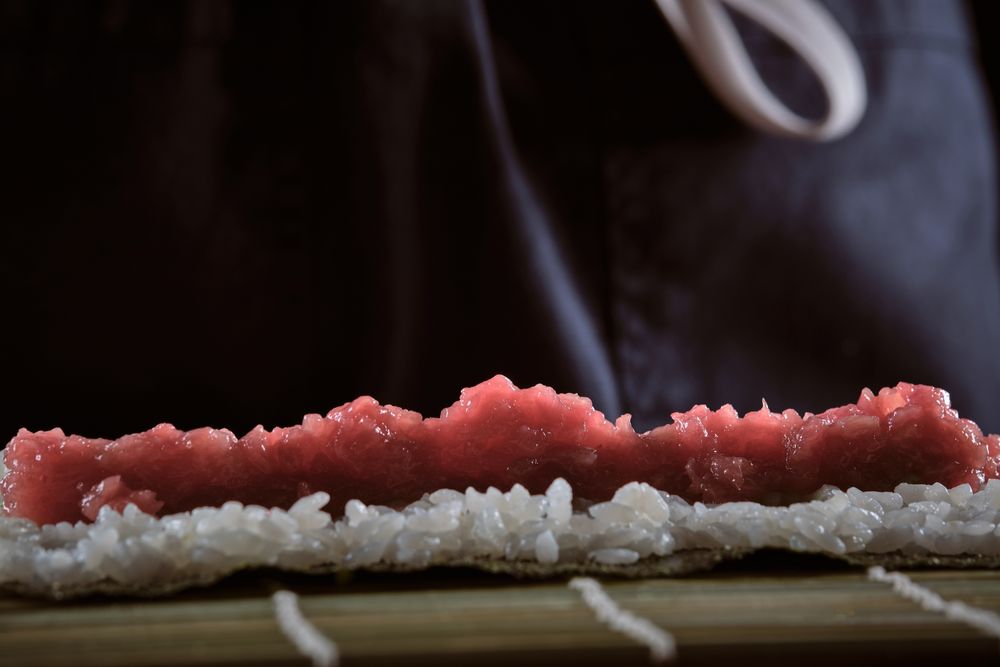 Male shushi man hands preparing different pieces of makis