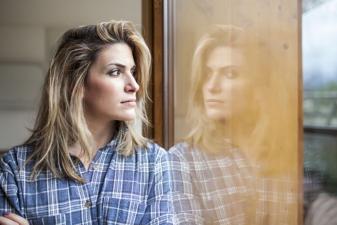 Woman at home looking at the windows