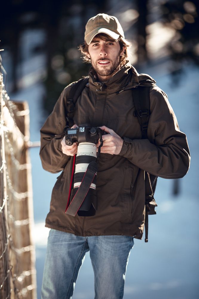 Man with camera in winter forest