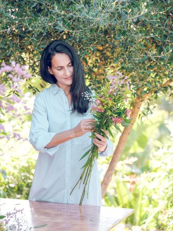 Brunette with flowers in summer garden