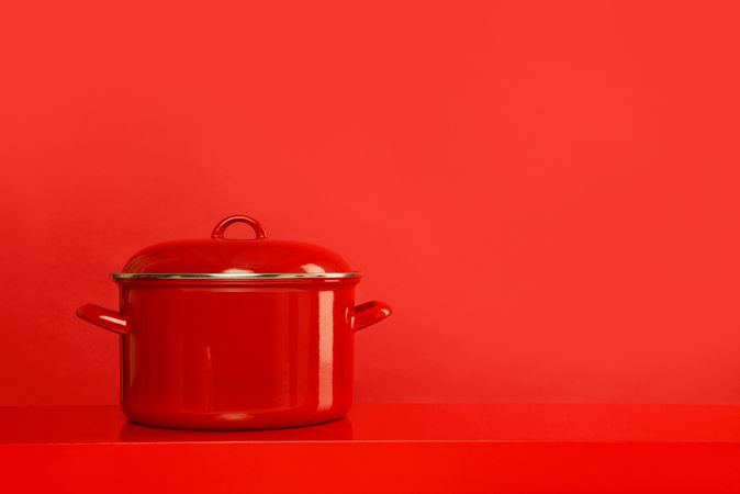 Red cooking pan on a red background with space for copy