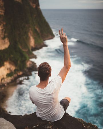 Traveler on high cliff viewing ocean