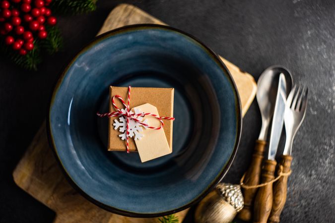 Navy plate with present, on table with holiday pine