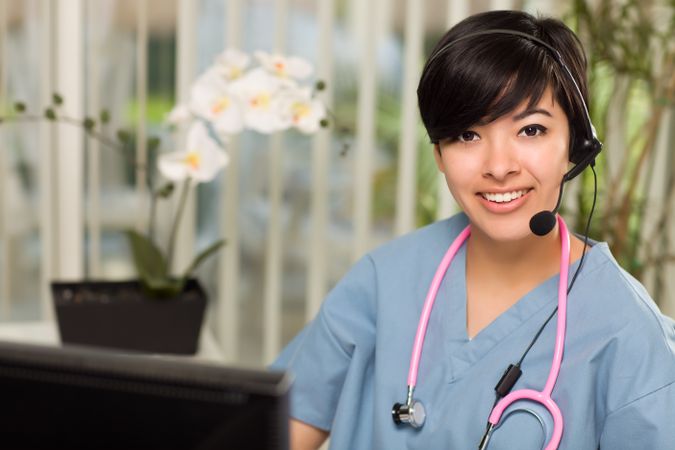 Woman Wearing Headset, Scrubs and Stethoscope