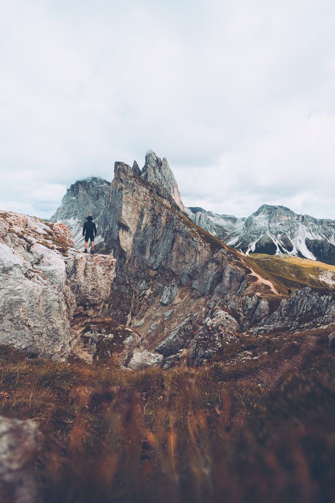Man standing on rock formation on a mountainous landform in Italy