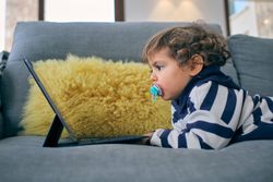 Little boy watching interesting cartoon at home