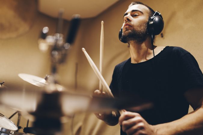 Man with headphones playing on drums