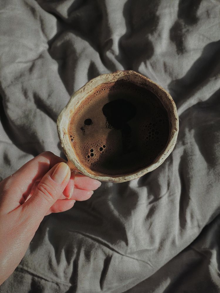 Female hand holding ceramic coffee cup