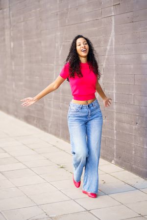 A Joyful Woman in a Colorful Outfit, Walking Happily Outdoors, Exuding Freedom and Fun