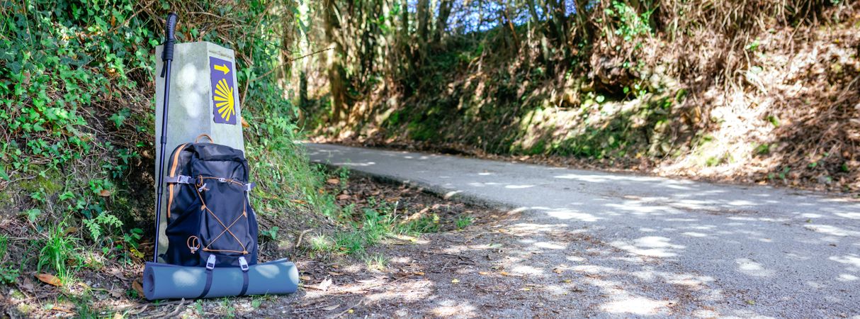 Milestone of Saint James way with backpack and hiking stick