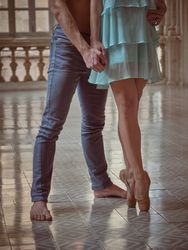 Woman in pointe shoes with partner in hall