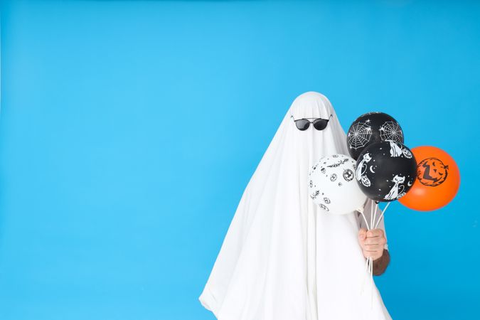 Concept of Halloween, Ghost in sunglasses on blue background