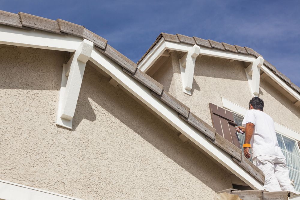 House Painter Painting the Trim And Shutters of Home