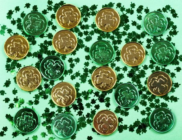 St Patrick’s Day with shamrocks and shiny coins on green background