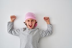 Excited kid screaming while celebrating victory over cancer