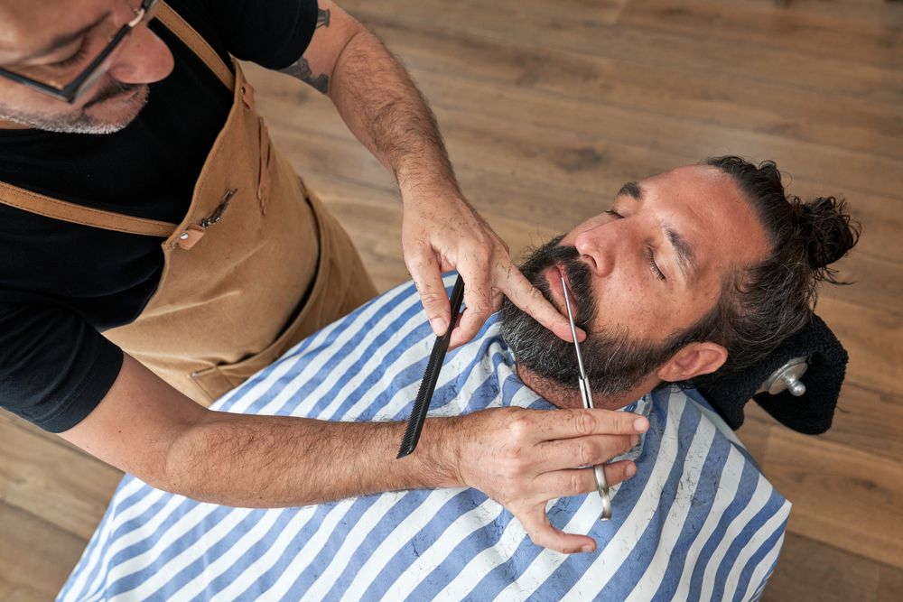 Professional barber cutting hair of customer in salon
